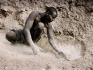Verso sera un ragazzo raccoglie la sabbia prodotta dal passaggio delle mandrie lungo la rampa di accesso ad un pozzo.